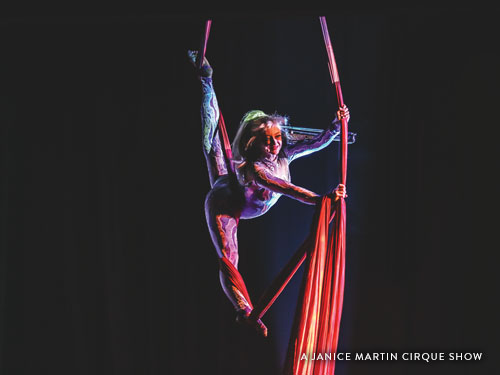 Women flying on areal ropes during a Branson cirque show.