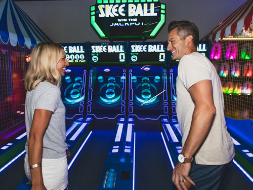 Couple playing skee ball at Bigfoot arcade.