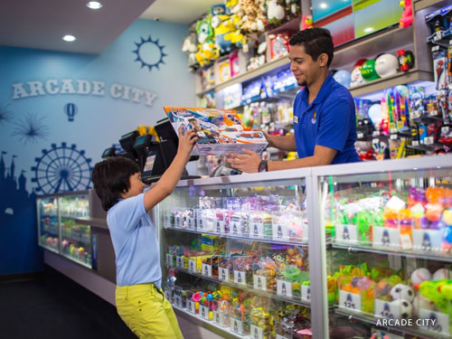 Young boy picking what he won with arcade tickets at an arcade prize counter in Branson.
