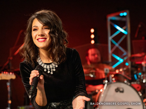 Woman star of Branson's Famous Baldknobbers show singing on a Branson live show stage.