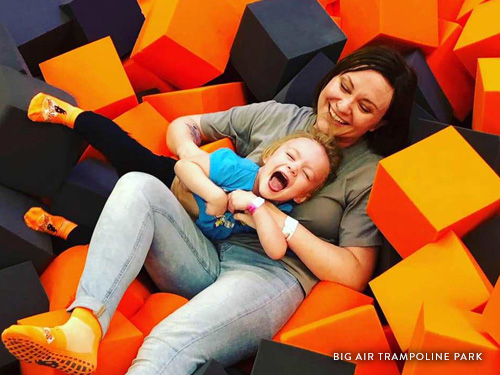 Mother and daughter laying in foam block pit in a trampoline park in Branson.