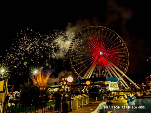Branson Ferris Wheel lit up by 16,000 LED lights at night shaped like a heart and surrounded by fireworks.