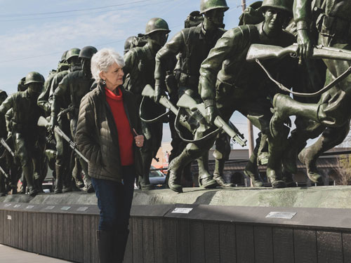 Woman Army veteran looking at a monument of fellow soldiers in Branson.