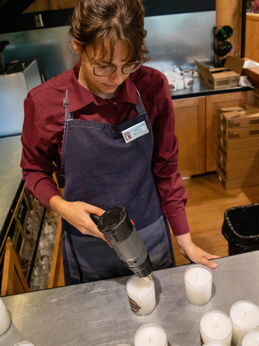 Student at College of the Ozarks making a candle at the Stained Glass and Candles Shop.