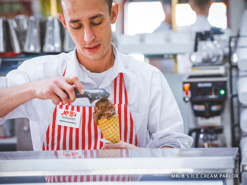 Man wearing white and red striped apron serving ice cream in Branson.