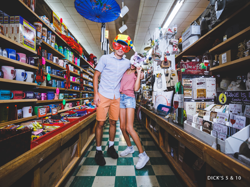 Brother and sister shopping in a novelty store and wearing funny hats and glasses in Downtown Branson.