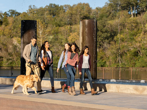 Family of five walking dog at outdoor shopping center in Branson.
