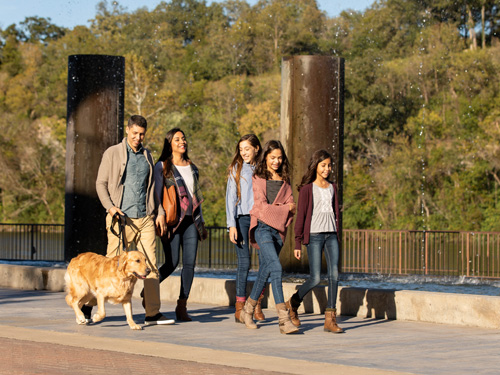 Family of five walking dog at outdoor shopping center in Branson.
