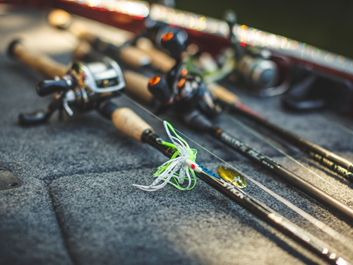 Fishing lures and poles sitting on boat deck.