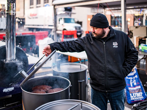 Man cooking barbecue in 55-gallon barrel in Branson.