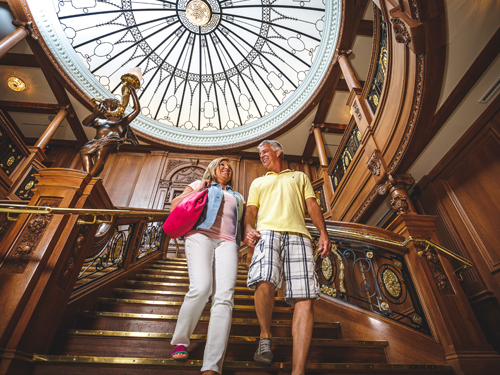 Middle-aged couple walking down the grand staircase at Titanic Museum Attraction in Branson.