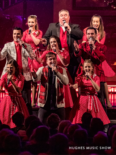 Family performing on a live Branson show stage in match red and white outfits.