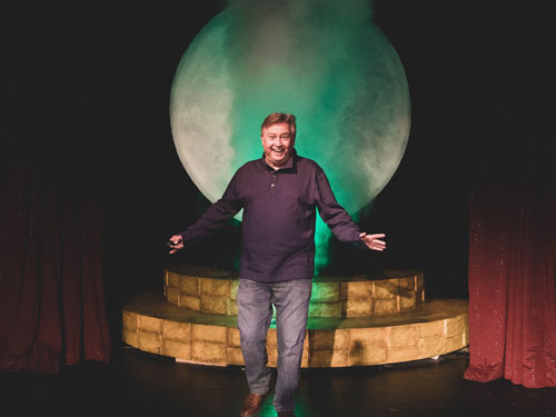 Man walking through smoke machine on Branson live show stage.