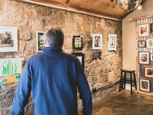 Man walking through art gallery displaying local art from Branson.