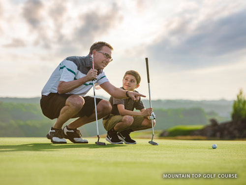 Father and son reading a putt on a golf course in Branson.