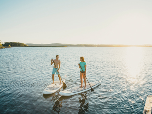 Man and woman paddleboarding on a lake in Branson.