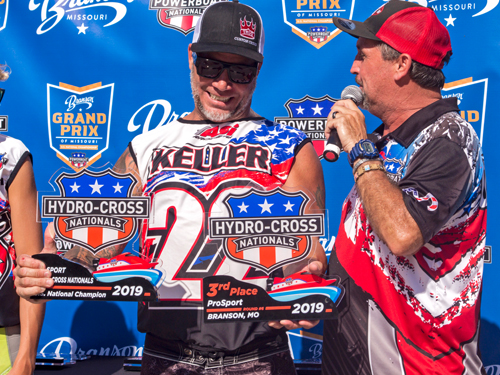 Man presenting trophy to winner of powerboat race in Branson.