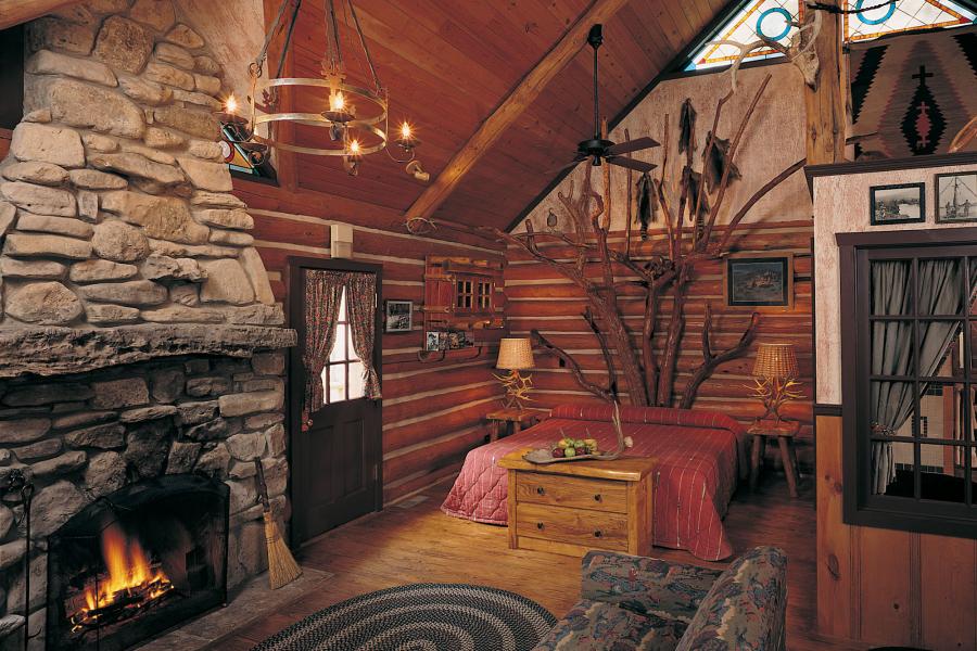 Interior of warm, wood cabin with fireplace burning.