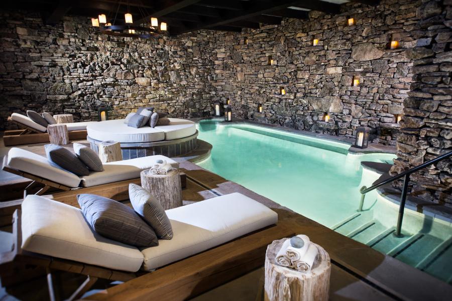 Relaxing spa with stone walls and a pool.