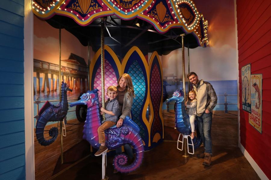 family poses in carosel photo op inside the new aquarium at the boardwalk in branson mo