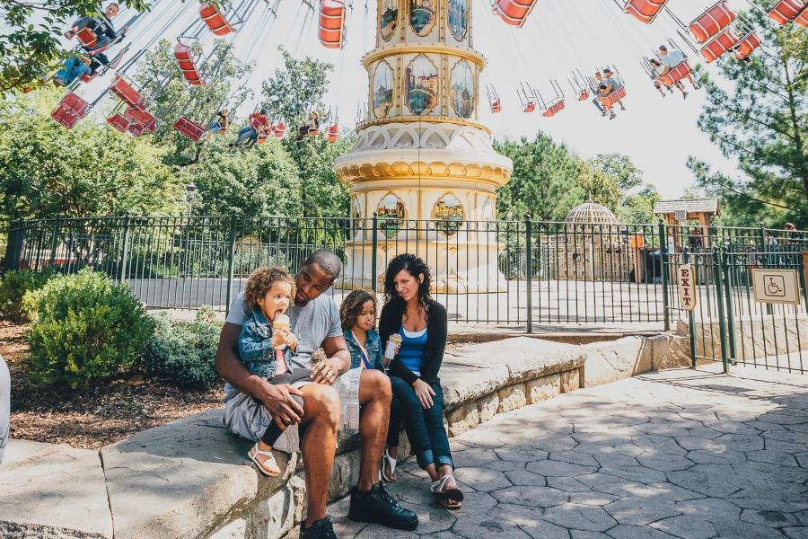 family enjoying ice cream cones in front of swing ride and silver dollar city in branson mo