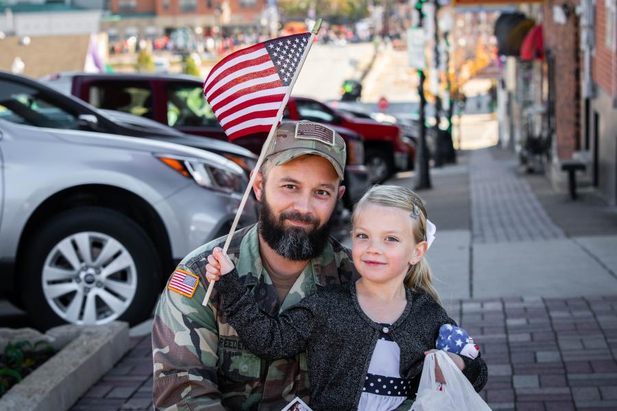 vet dad with daughter and flag downtown