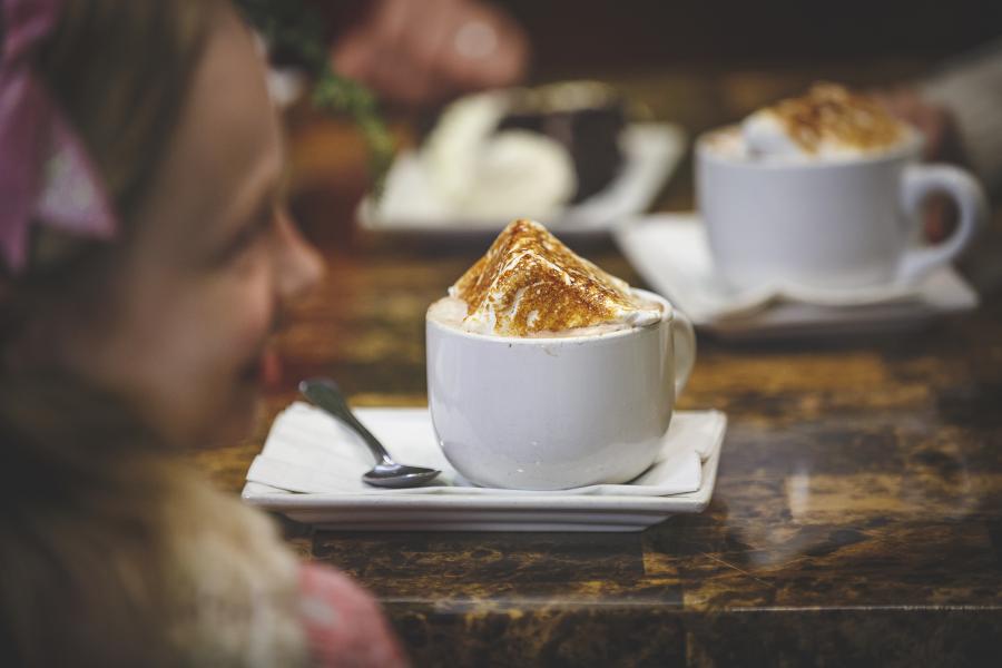kid with beverage topped with cinnamon