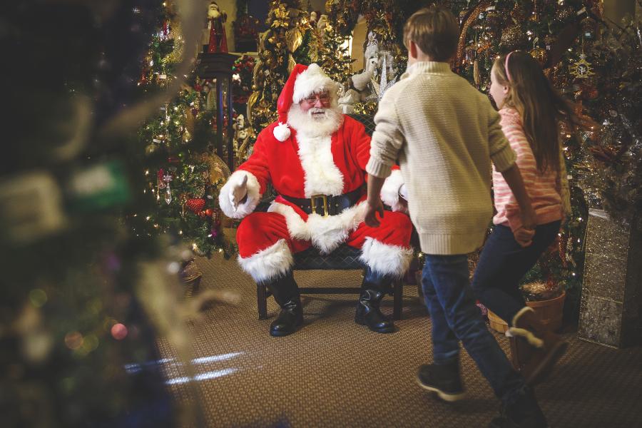 kid walking to santa's lap at grand village in branson