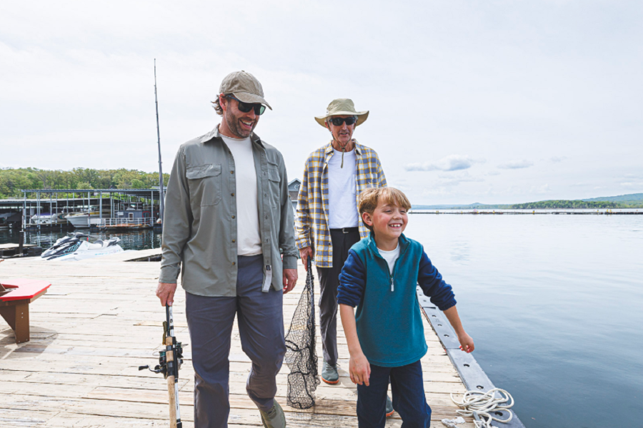 Father, son, and grandfather with fishing gear on a dock by the Table Rock Lake