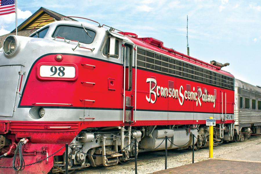 Red historic train leaving from a train depot in Historic Downtown Branson.