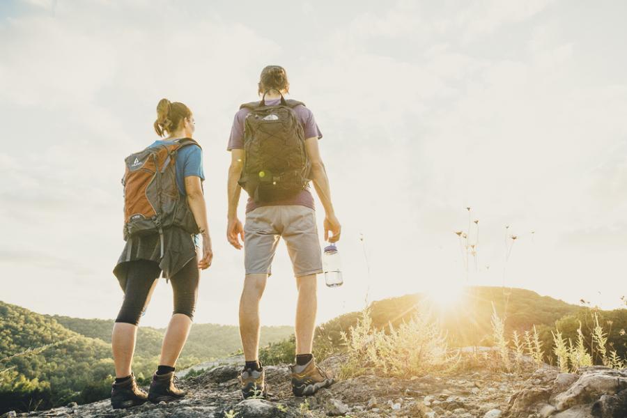 Man and woman looking at the sunrise on a scenic hike in Branson.