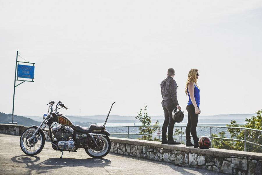 Man and women standing at a scenic overlook in Branson next to their motorcycle.