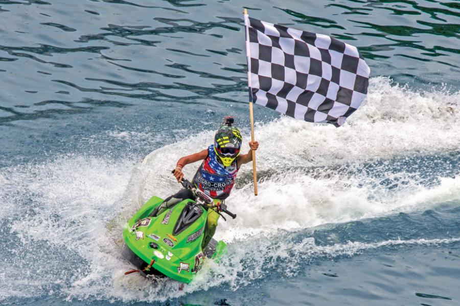 Powerboat driver holding flag during race in Branson.