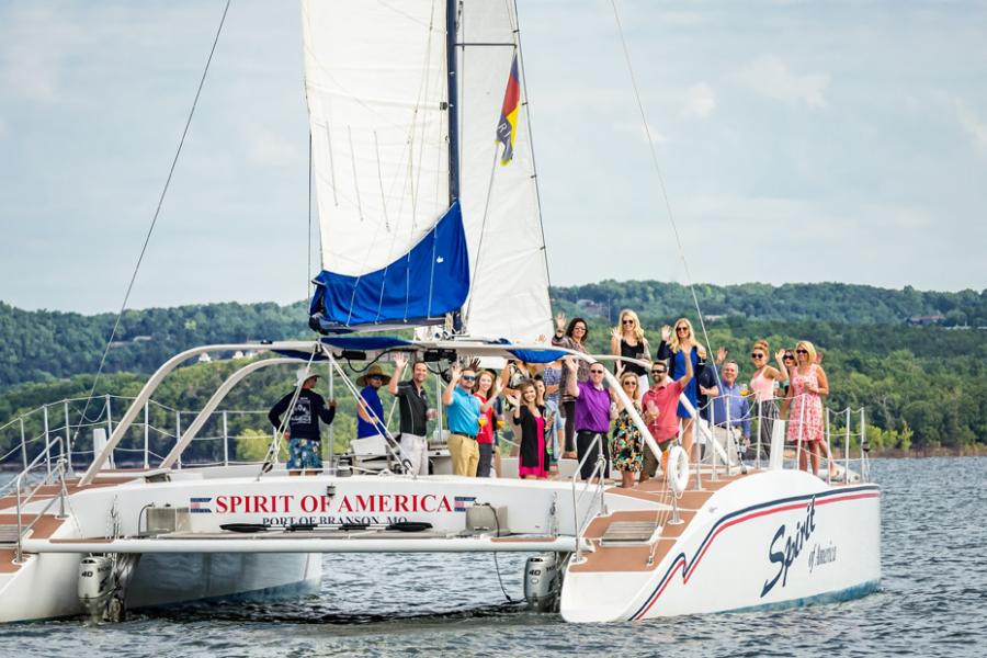 Group of business partners conversing on a catamaran in Branson.