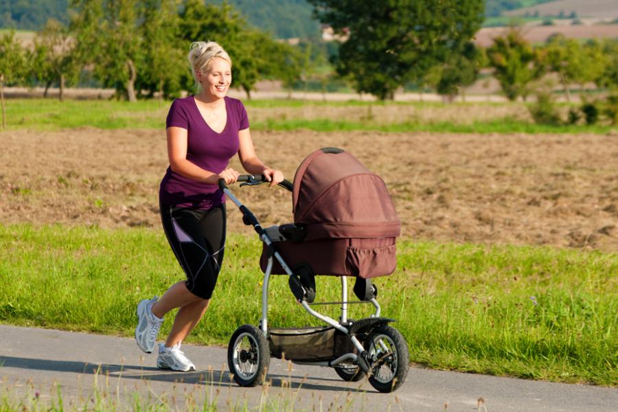 Mom pushing stroller with child inside during an outdoor jog in Branson.