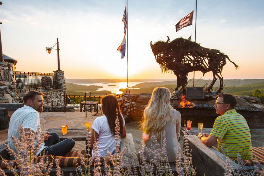 Two couples on a date at an upscale restaurant in Branson that overlooks a lake and a sunset. 