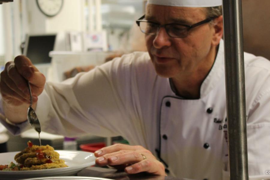 Executive chef decorating a plate of food to be served at the Keeter Center restaurant in Branson.