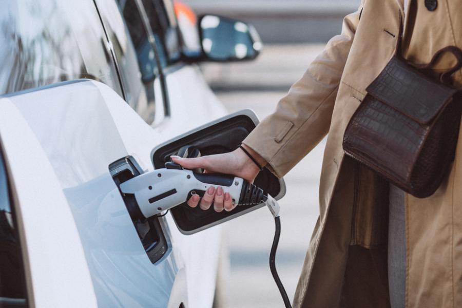 Woman charging electric car. 