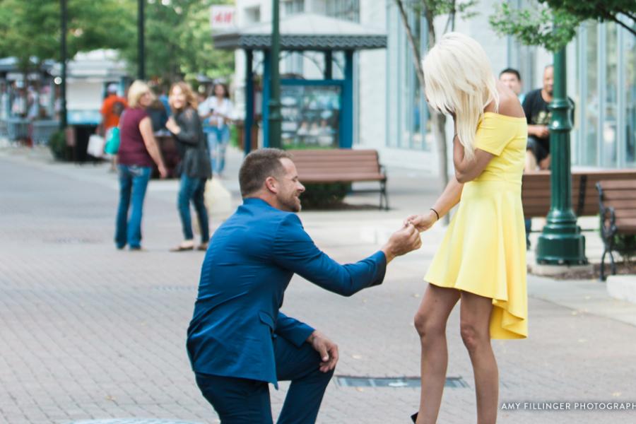 Man on one knee proposing to girlfriend.