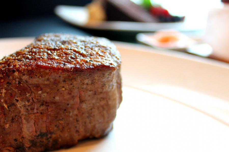 A cut of thick steak from Level 2 Steakhouse on a white plate.