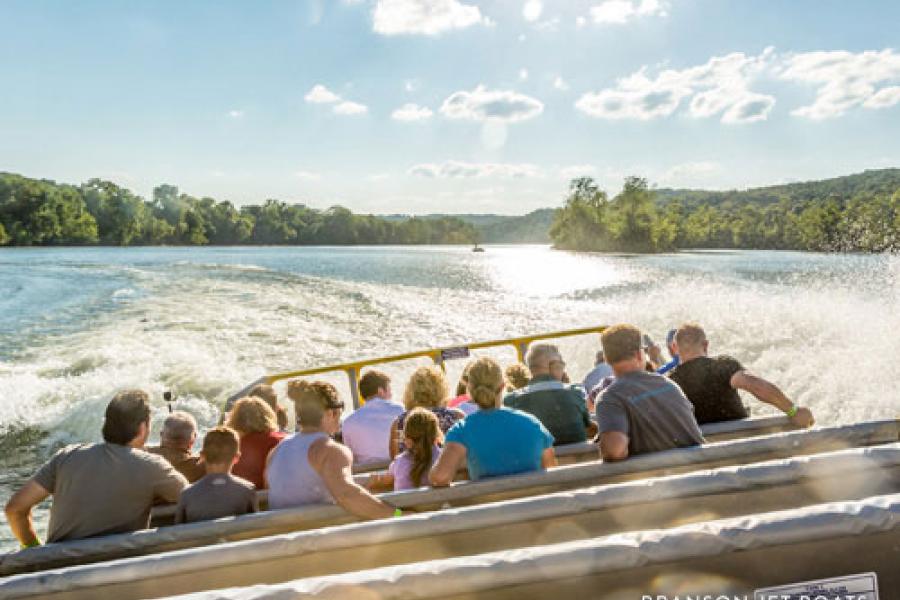 People being splashed and enjoying thrilling boat attraction. 