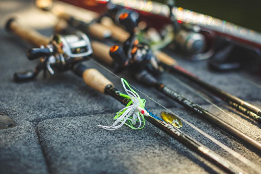 Fishing lures and poles sitting on boat deck. 