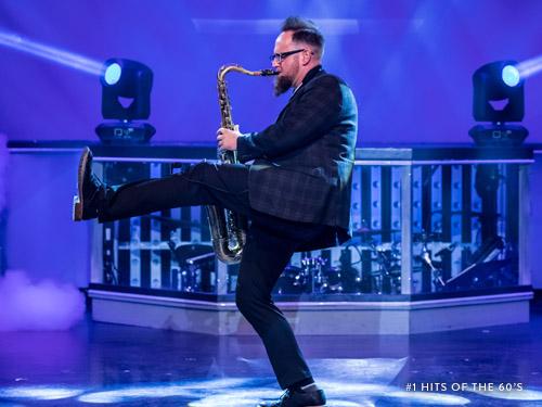 Performer playing saxophone on a Branson live show stage.