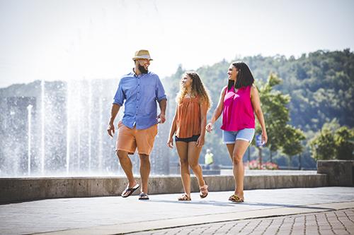 family walking at branson landing by fountain show