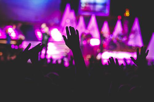 theatre crowd with hands up at exciting branson show