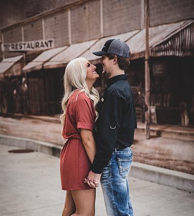 couple posing for photoshoot in front of branson downtown mural