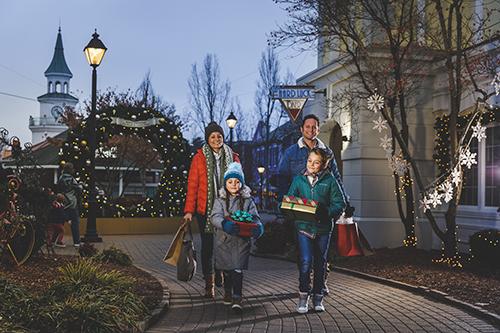family walking with shopping bags in grand village in branson during christmas