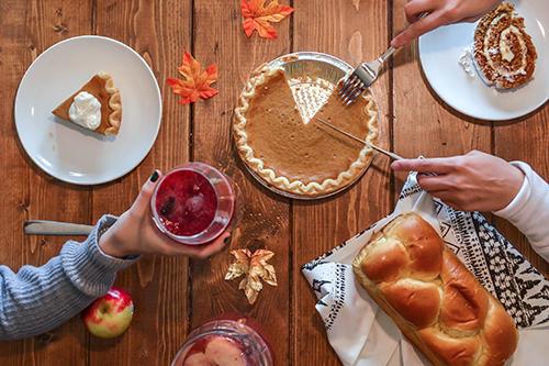family cutting pumpkin pie on thanksgiving