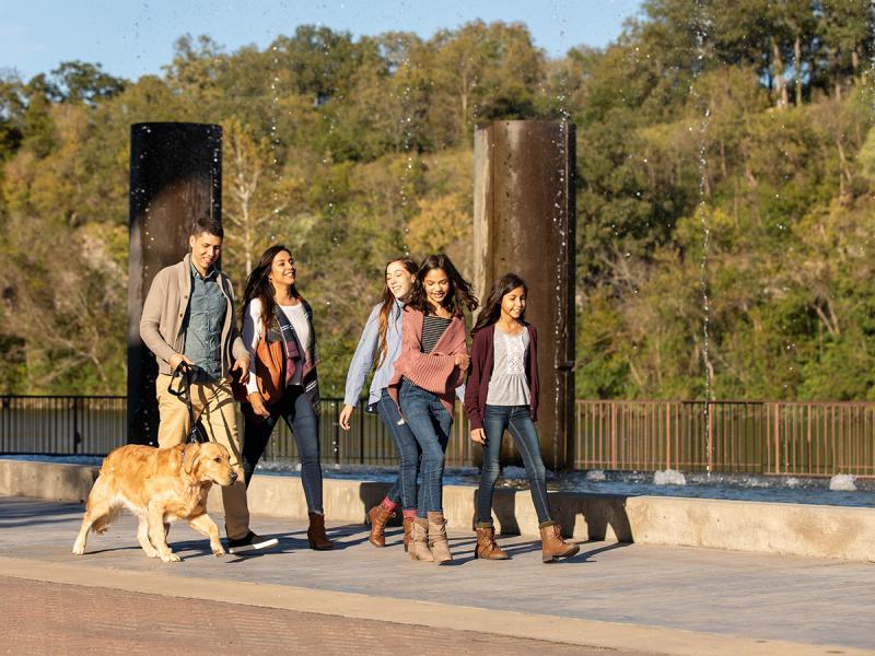 A family walking their dog on the Branson Landing.