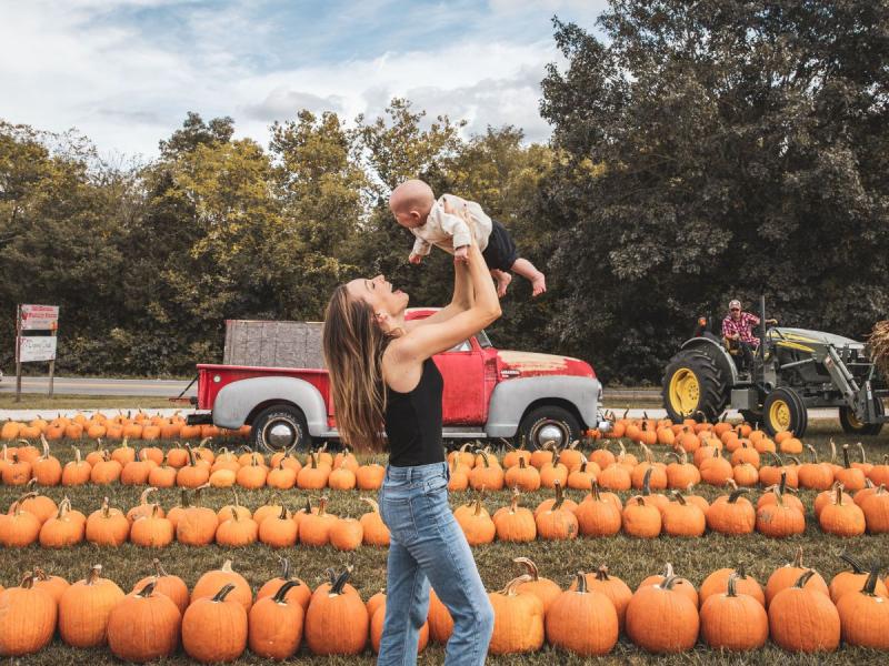 woman with baby at pumpkin patch branson mo